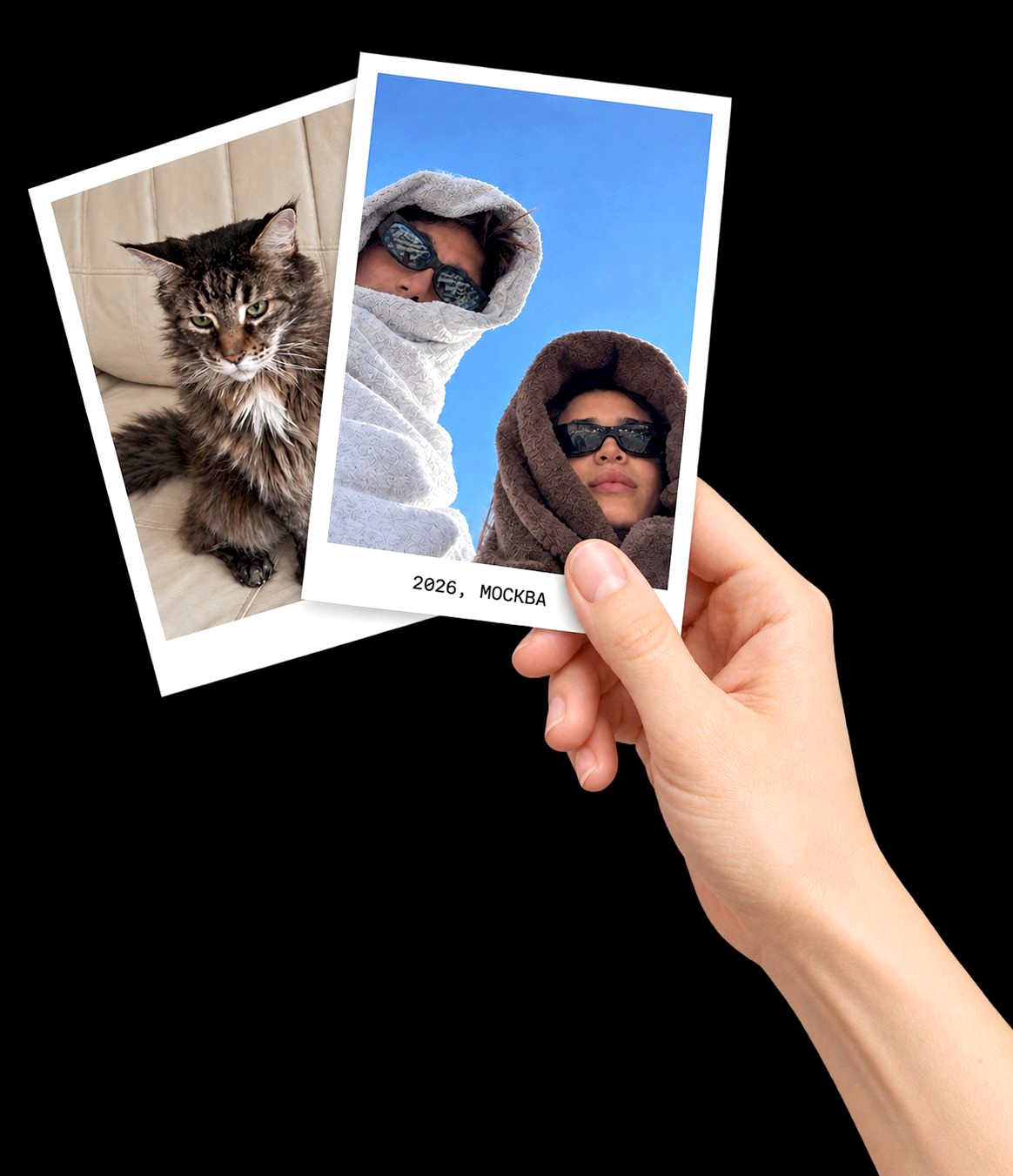 A hand holding two printed photos in white frames